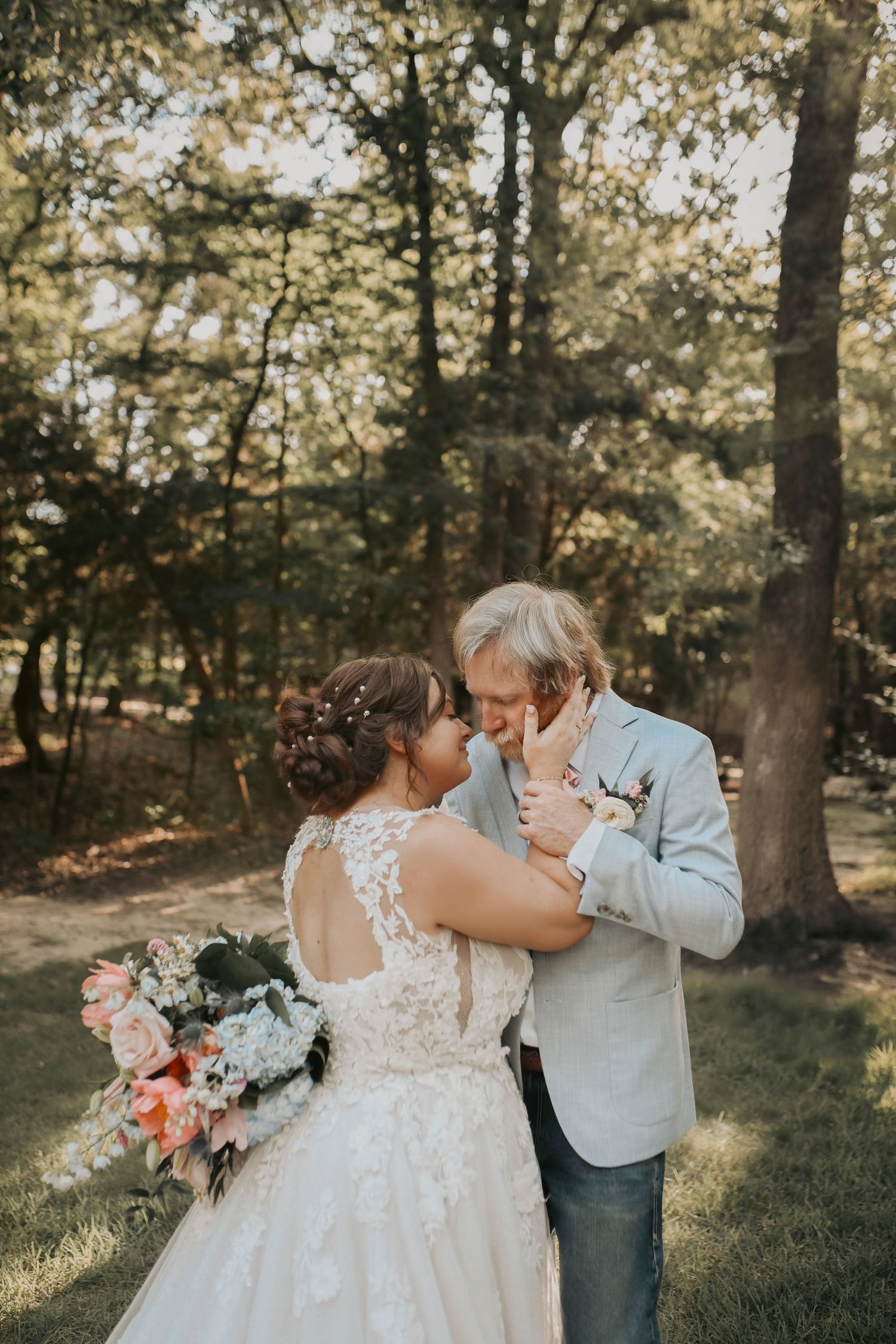 Couple dancing in soft golden light surrounded by spring greenery