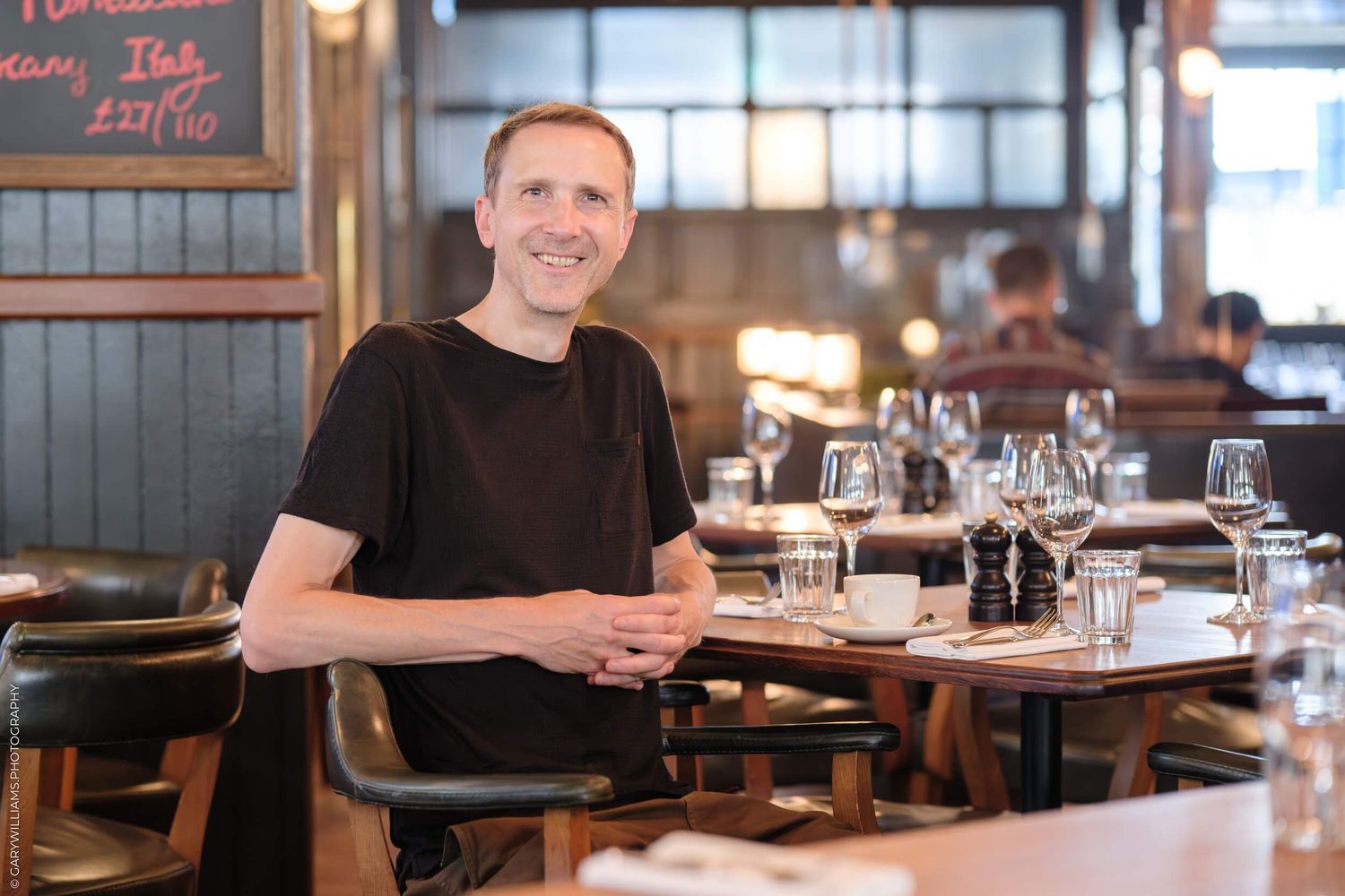 A series of restaurant interior shots showing dining tables, wooden decor and ambient lighting in a rustic setting.