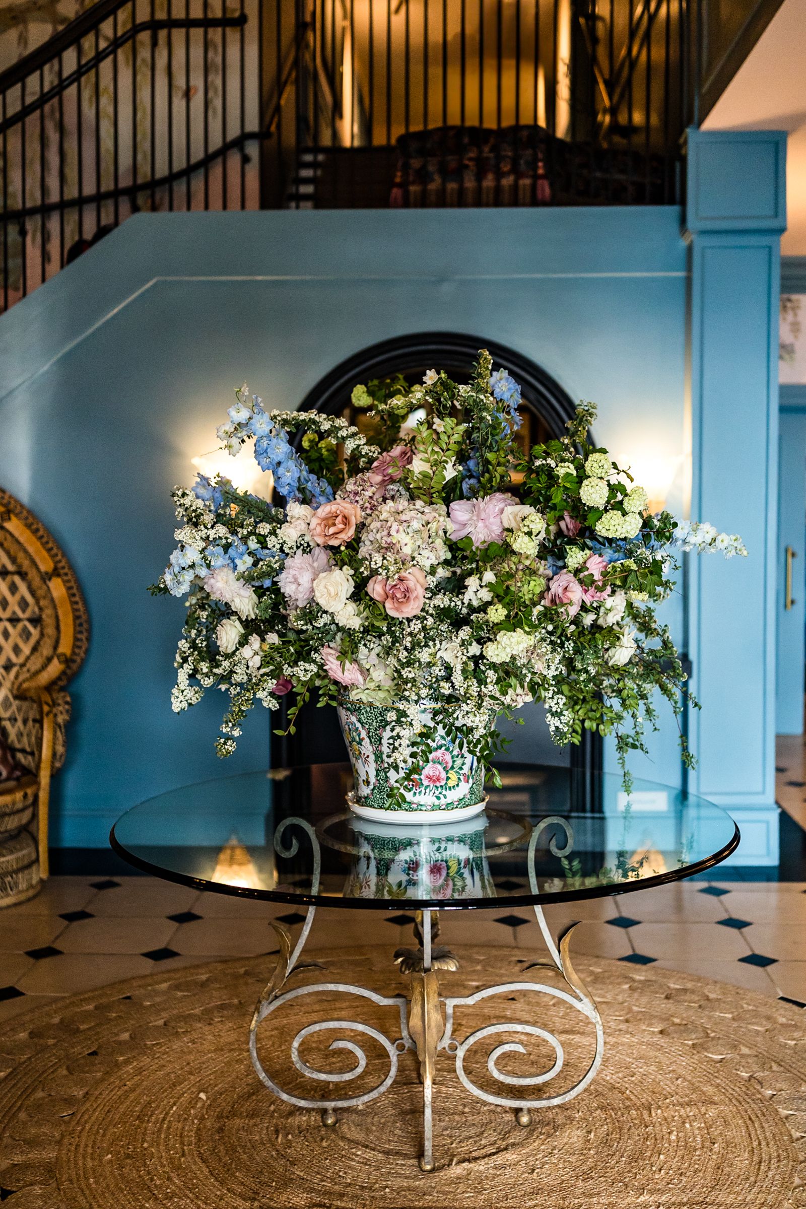 Progression of floral centerpiece arrangement shots showing pink and white flowers in glass vases on a round textured surface.