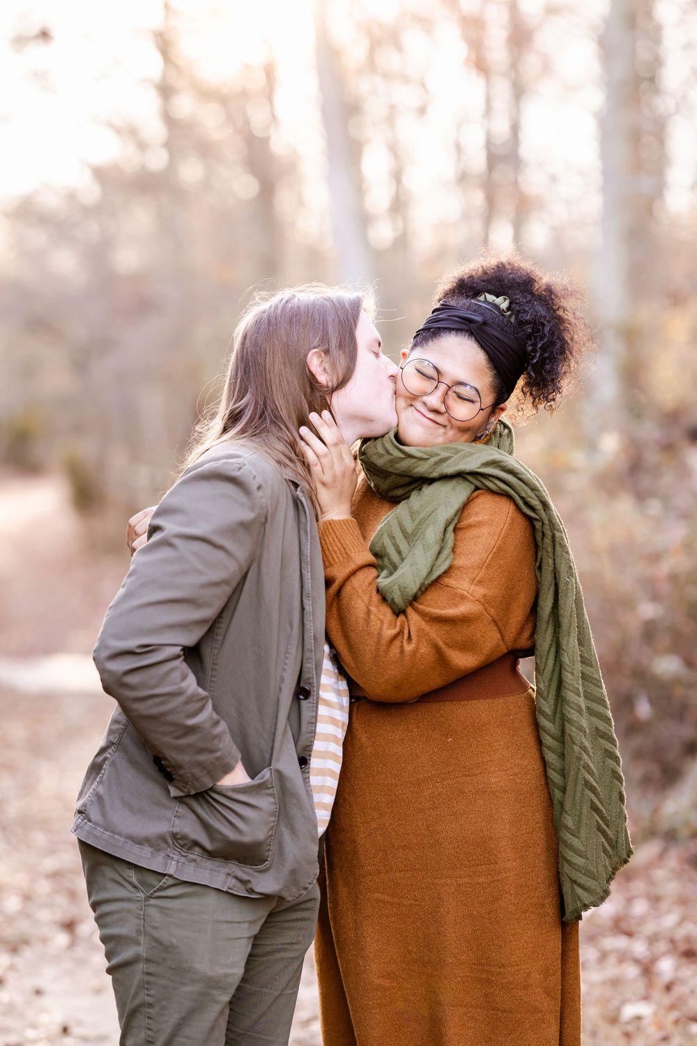 A tender moment shared between two people on a fall day in the woods.