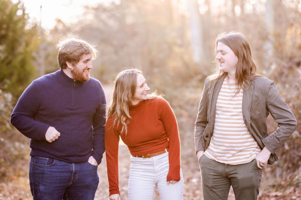 Three friends enjoying a casual walk together on a scenic fall trail.