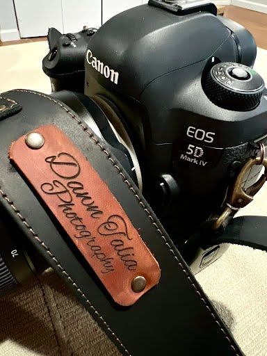 Canon EOS 5D camera with a leather camera strap featuring a personalized rose gold Forever Young engraving.