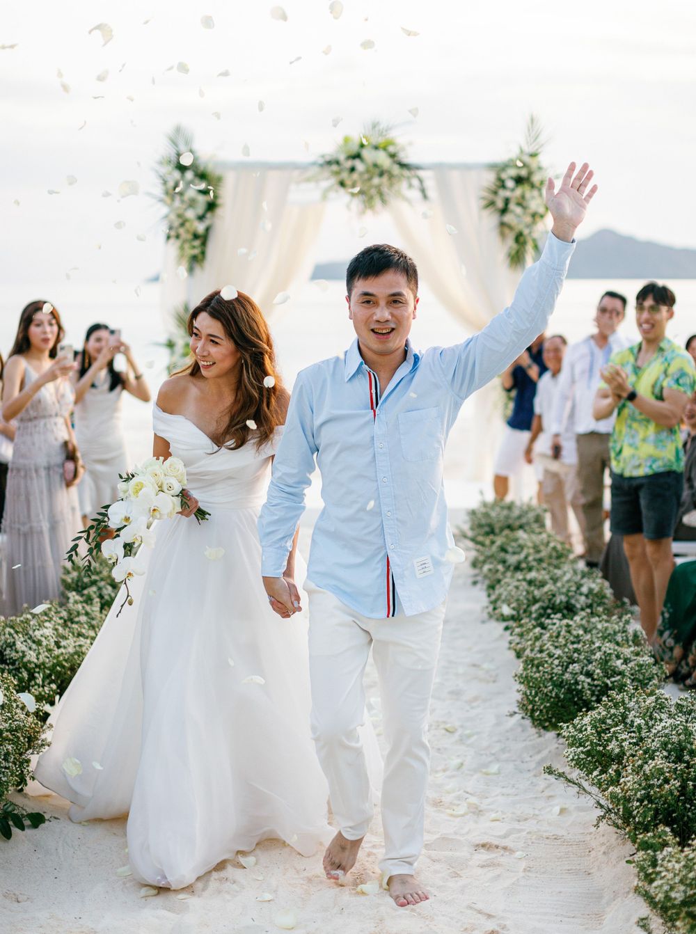 Professional photographer at a Philippines wedding on the beach, capturing a couple exiting their ceremony in Amanpulo.