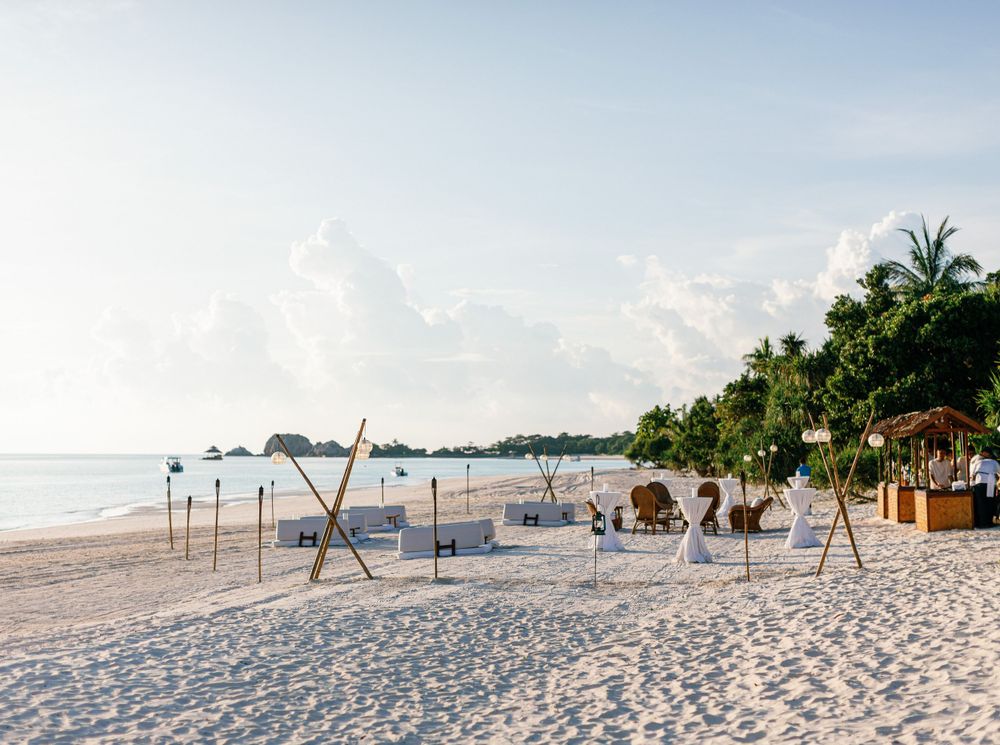 Wedding cocktail setting on a white sandy beach at Aman resort in Amanpulo, Philippines.