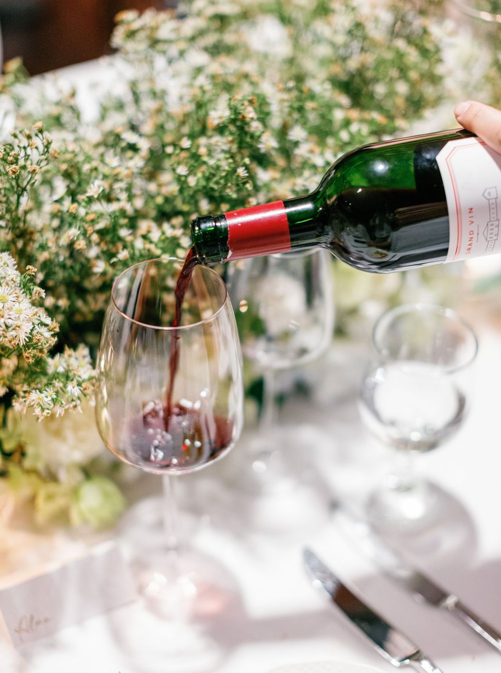 Red wine being poured into glass at wedding reception, Aman resort, Amanpulo, Philippines.