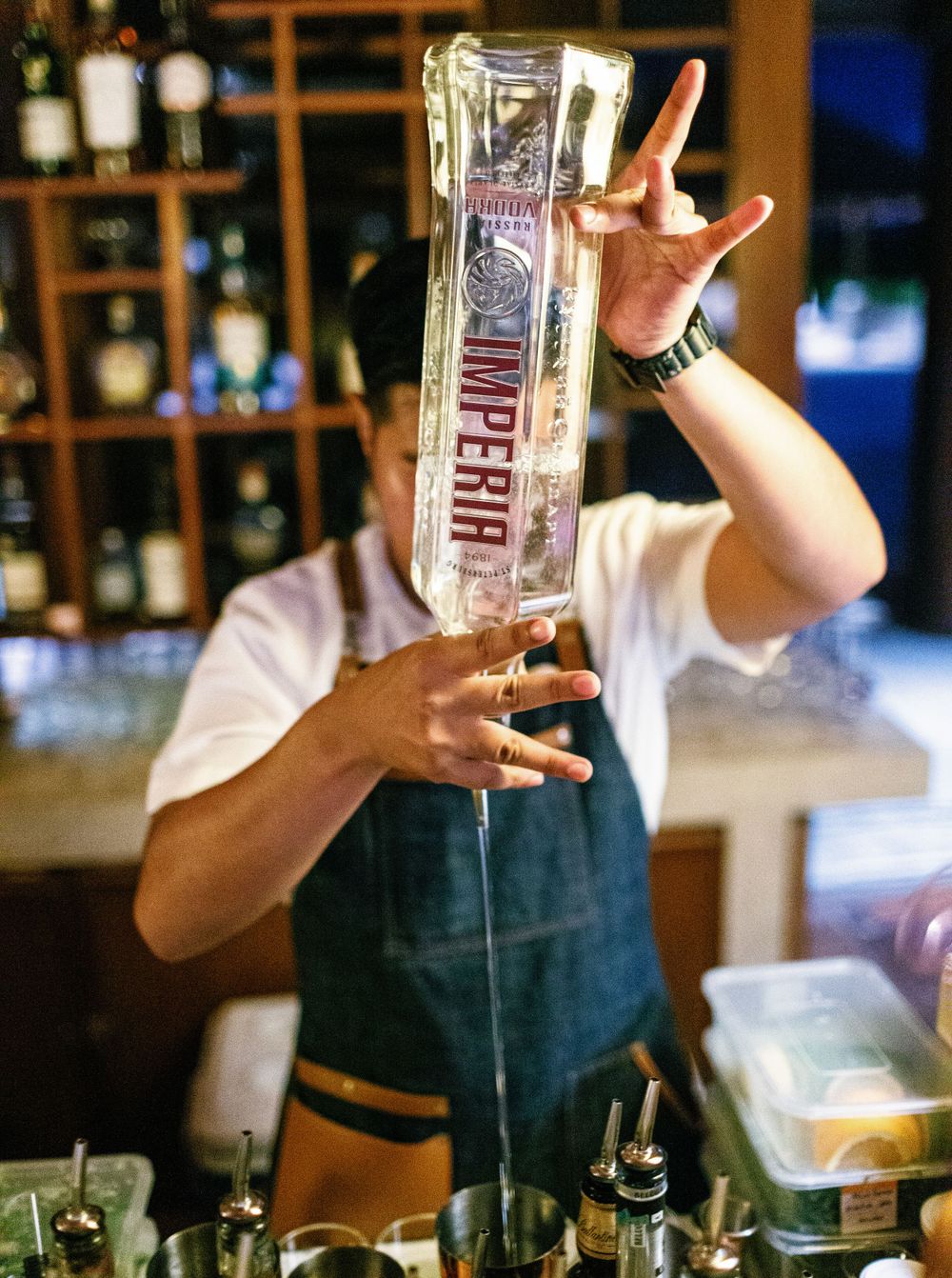 Bartender pouring a drink into a glass at a wedding reception in Aman resort, Amanpulo, Philippines.