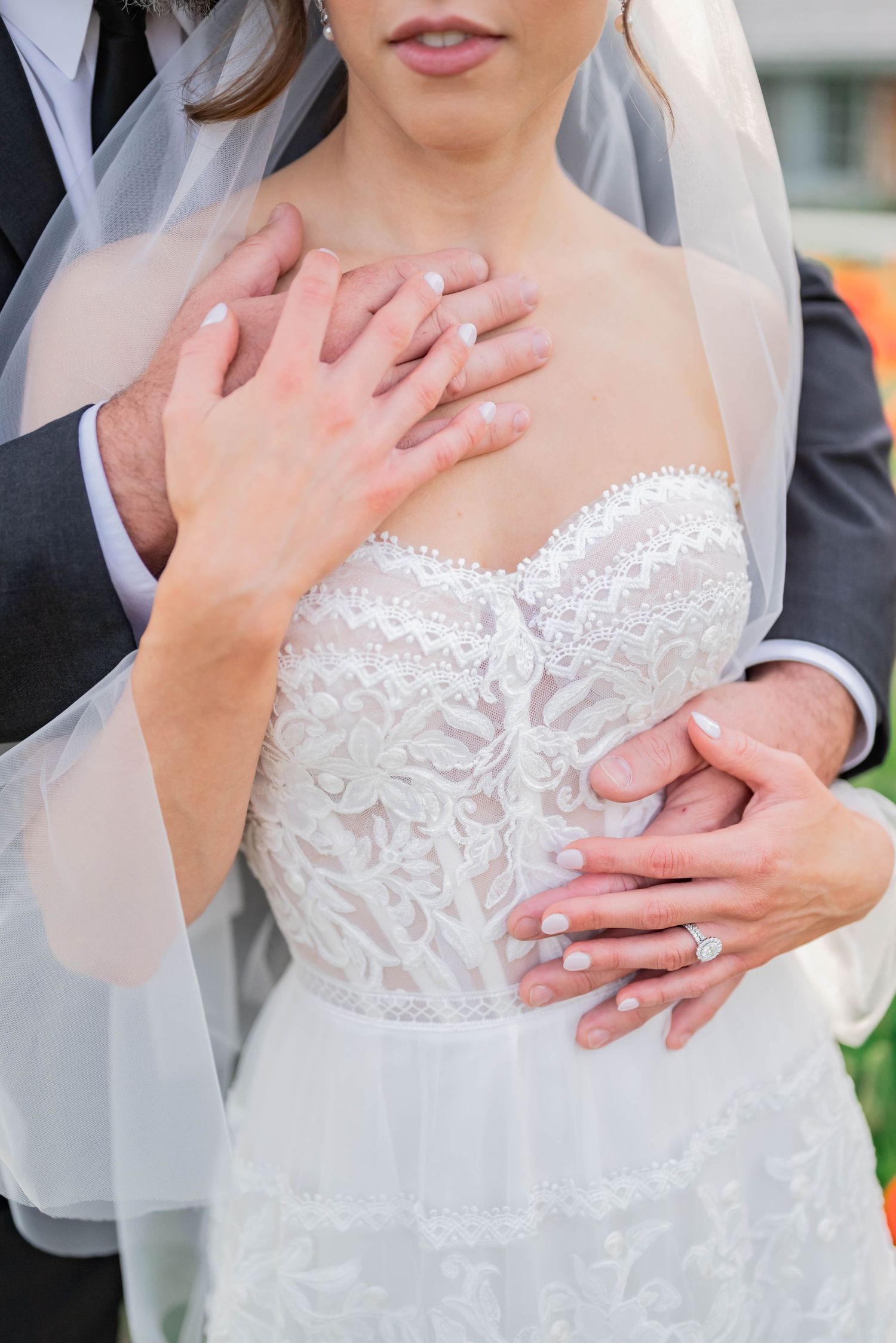 Detail shots of lace wedding dress with delicate hands and romantic veil.