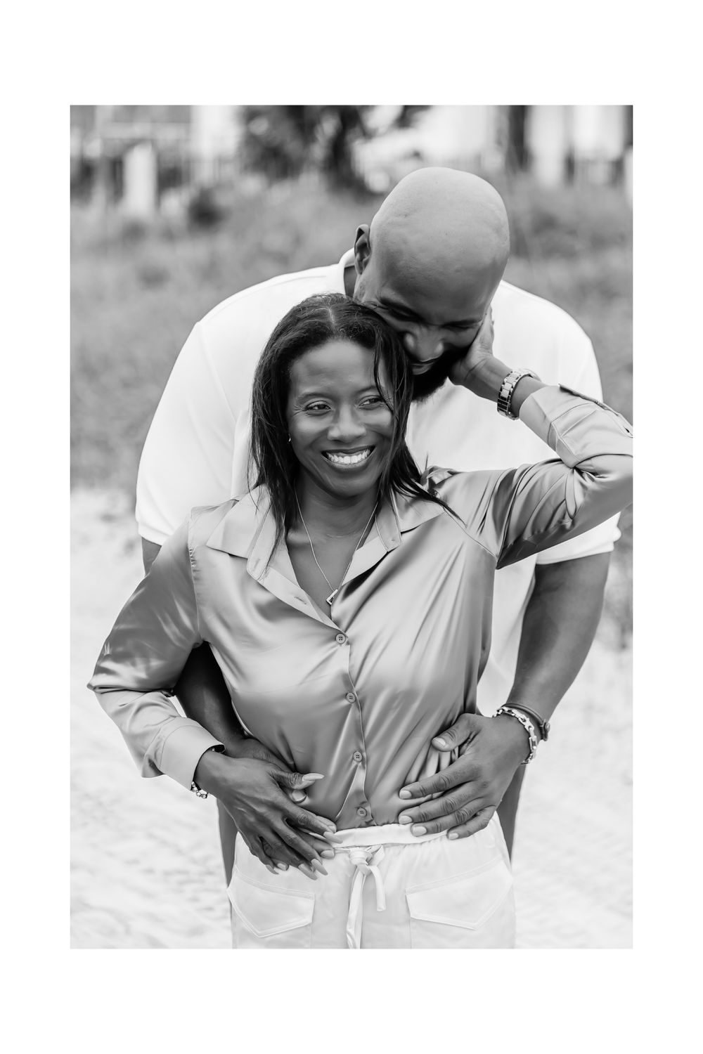 A black and white outdoor engagement photo series showing a couple laughing and embracing.