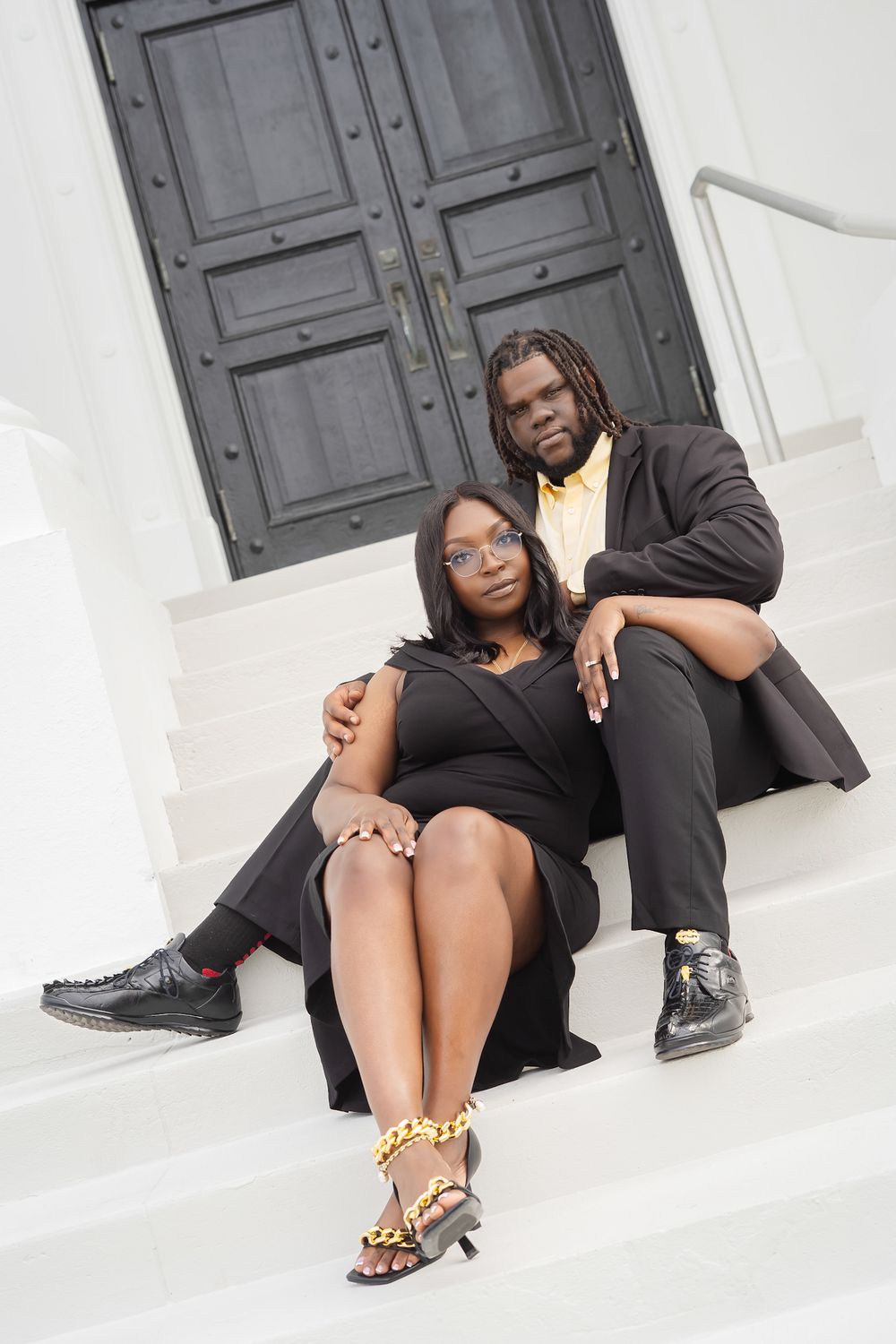Fashion portrait series showing stylish footwear and black outfits against white architectural background.
