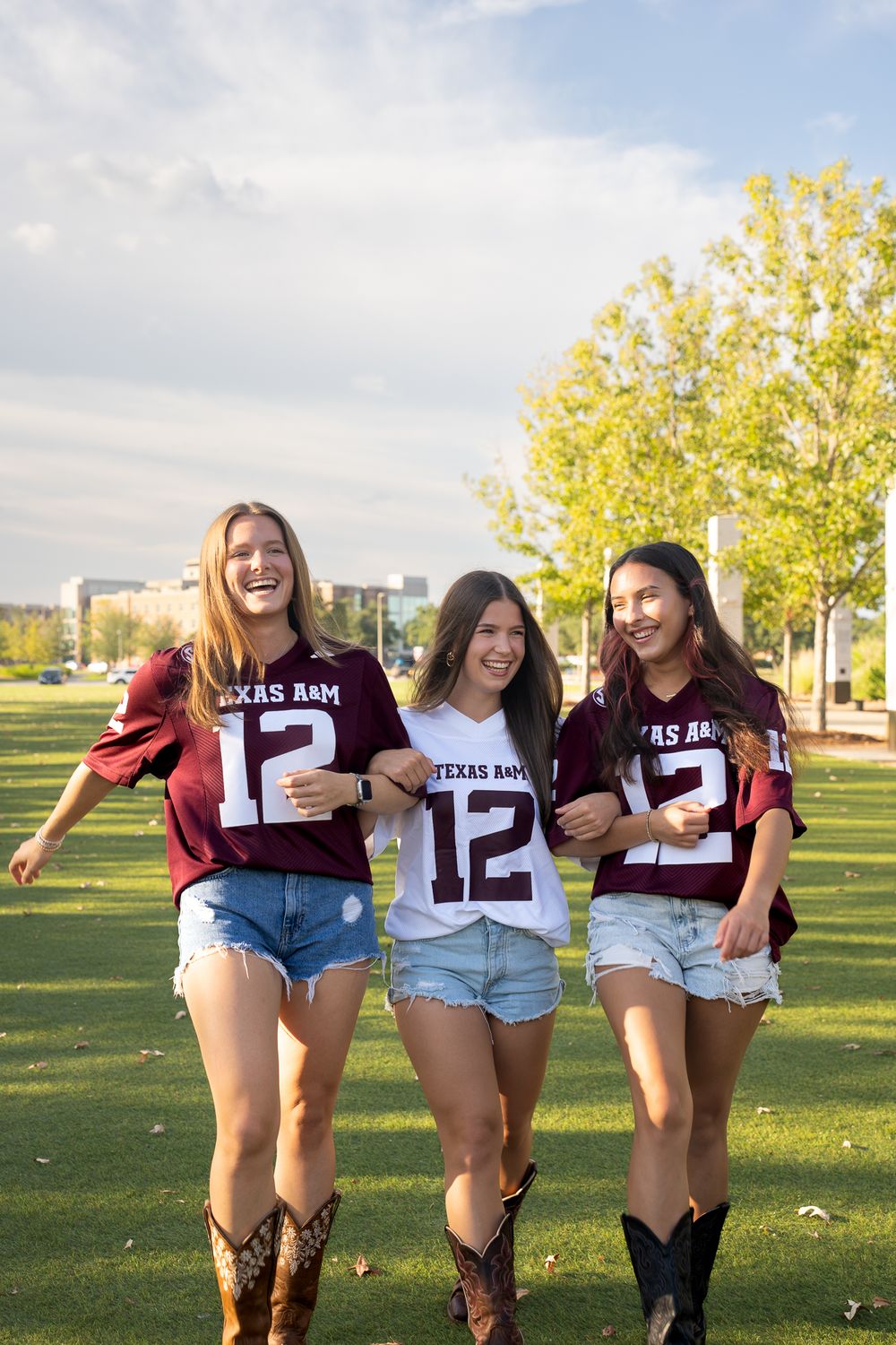 Girls in Aggie football jerseys enjoying a portrait session, celebrating school spirit in College Station, Texas.