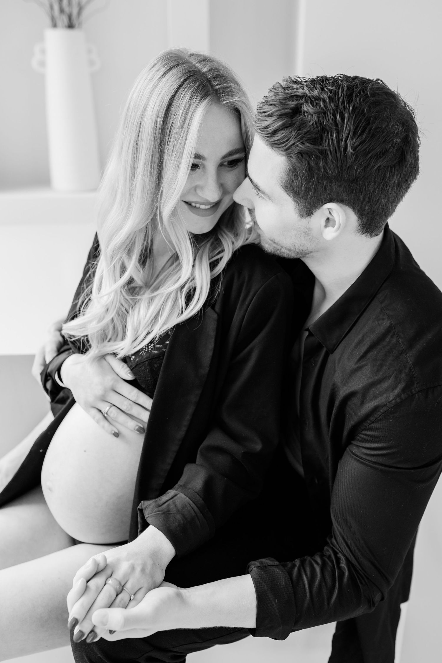 A romantic black and white photo series showing tender moments between a couple in matching dark outfits.