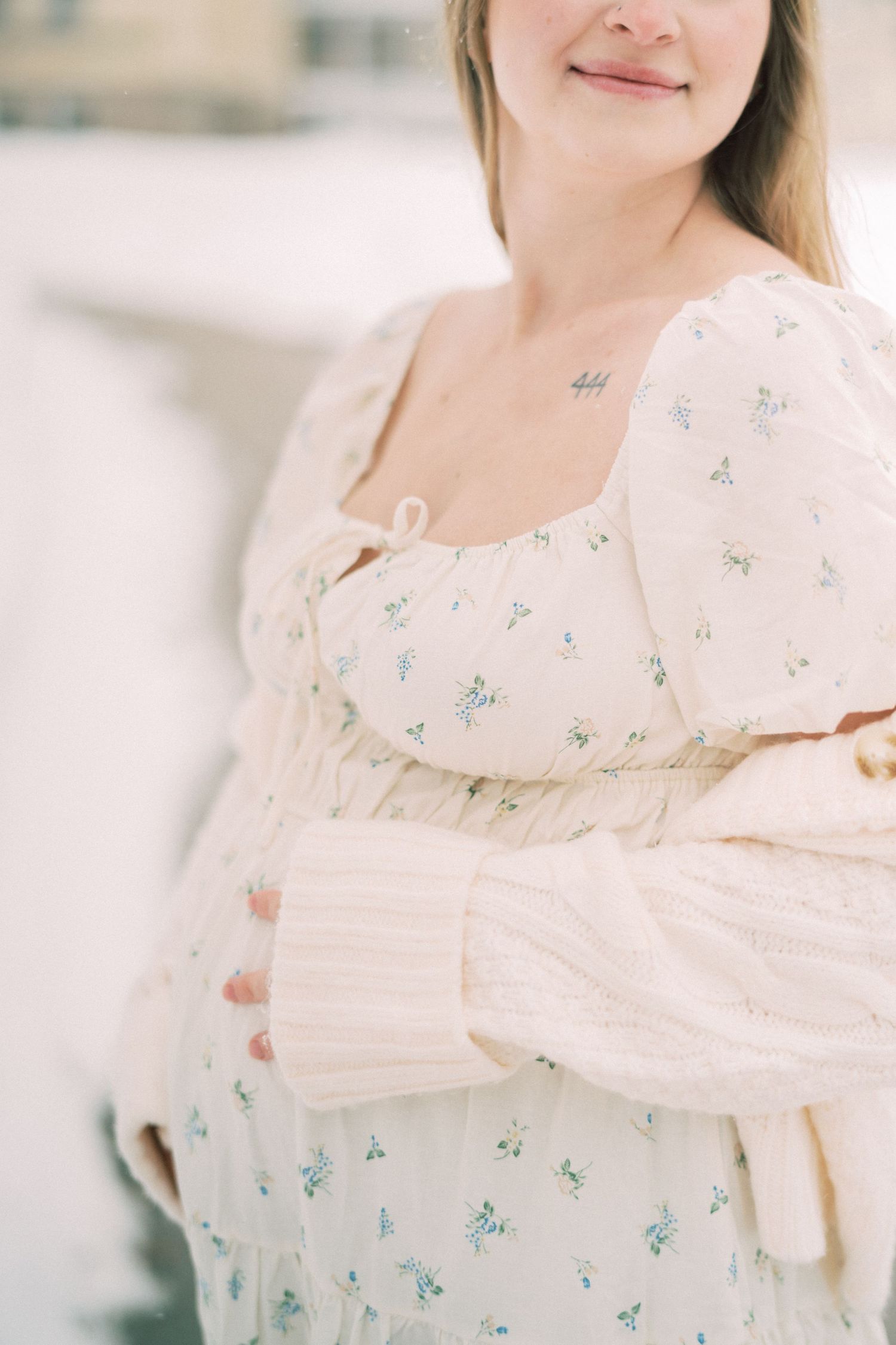 A feminine silhouette wearing a romantic cream-colored dress with delicate floral prints and puff sleeves.