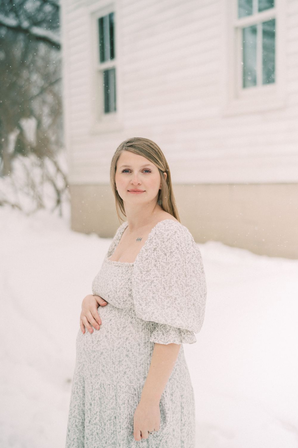 Soft pastel portrait of someone wearing a delicate white lace dress against a snowy outdoor backdrop.