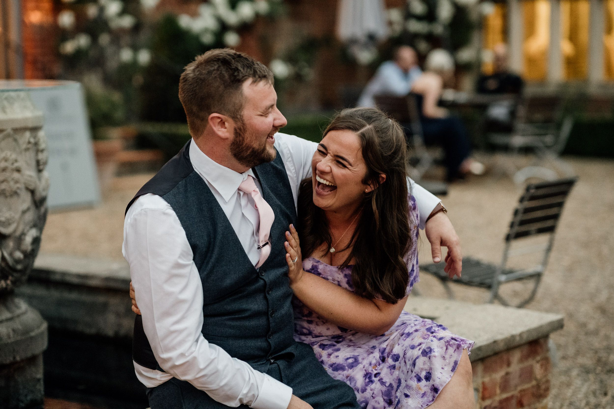 A couple shares joyful candid moments together during an outdoor wedding photoshoot.