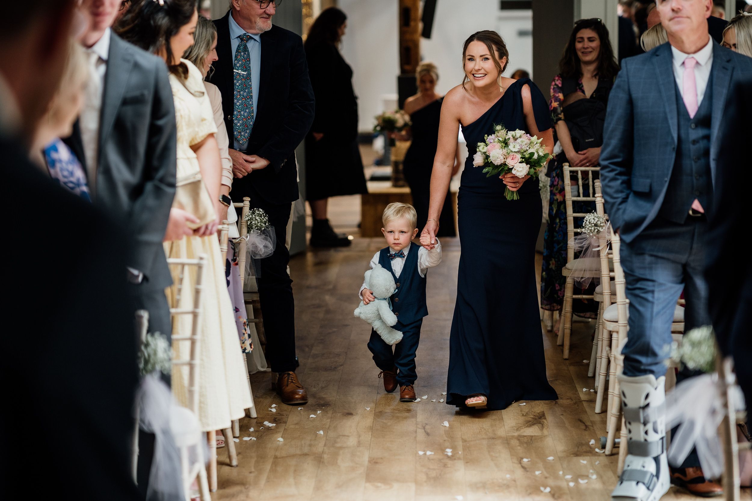 The wedding procession walks down the aisle in an elegant indoor Oxnead Hall.