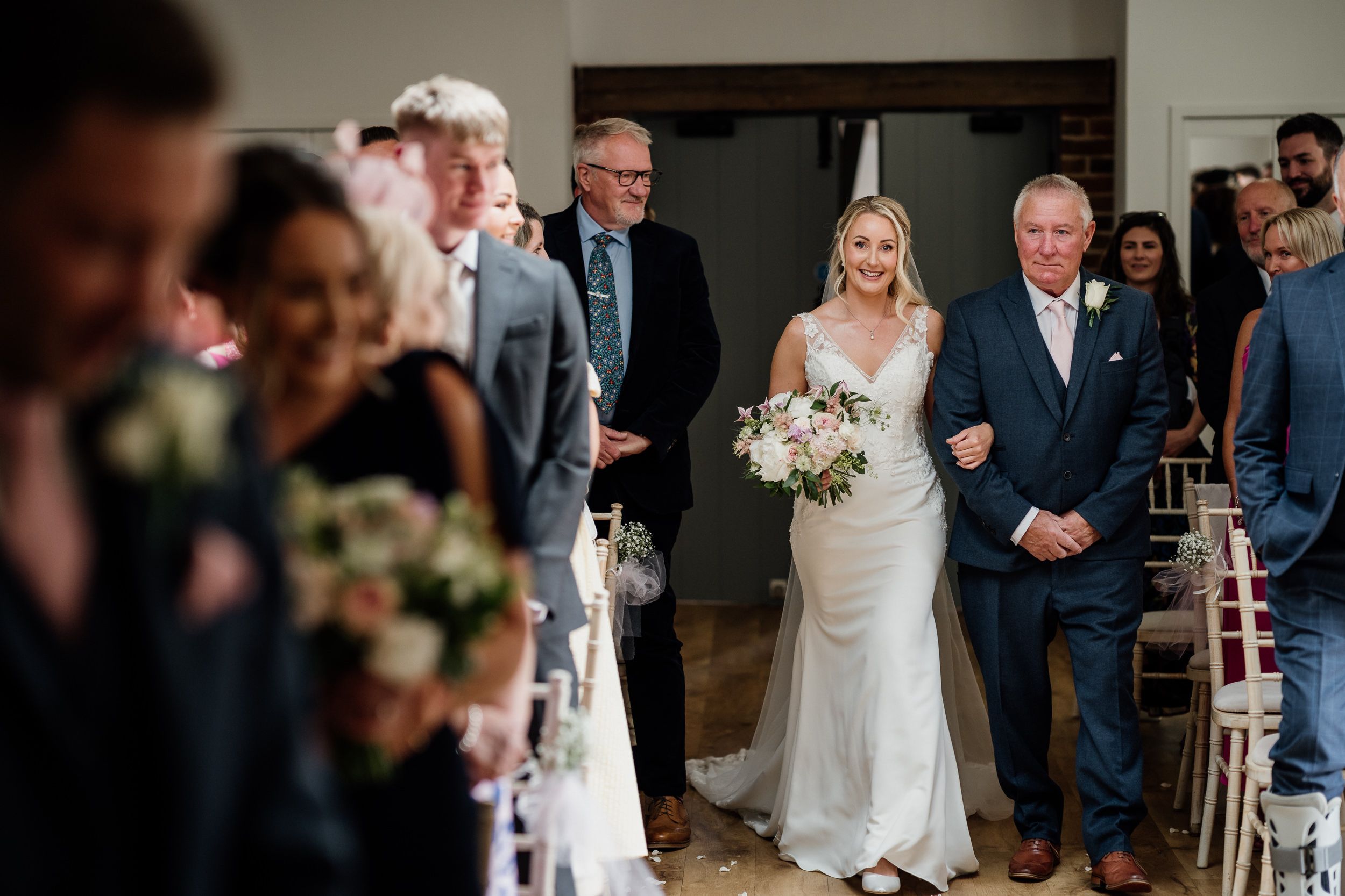 Wedding ceremony at Oxnead Hall, entrance with a bride in a white wedding dress walking down the aisle, accompanied by her father.
