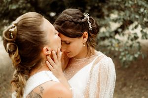 A loving couple shares a tender intimate moment in a rustic outdoor setting bathed in warm golden sunlight.
