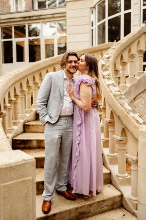 A couple shares romantic moments on an ornate stone staircase in a series of photos showing affection and intimacy.