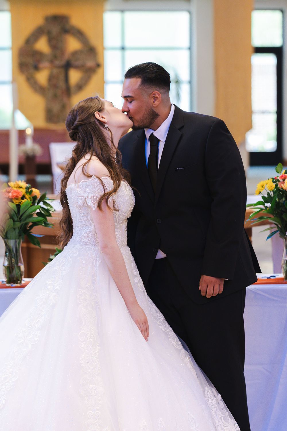 Romantic wedding ceremony scene with couple sharing their first kiss as newlyweds.