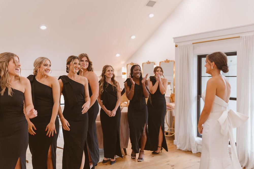 Wedding party wearing black reacting emotionally during a first look reveal.
