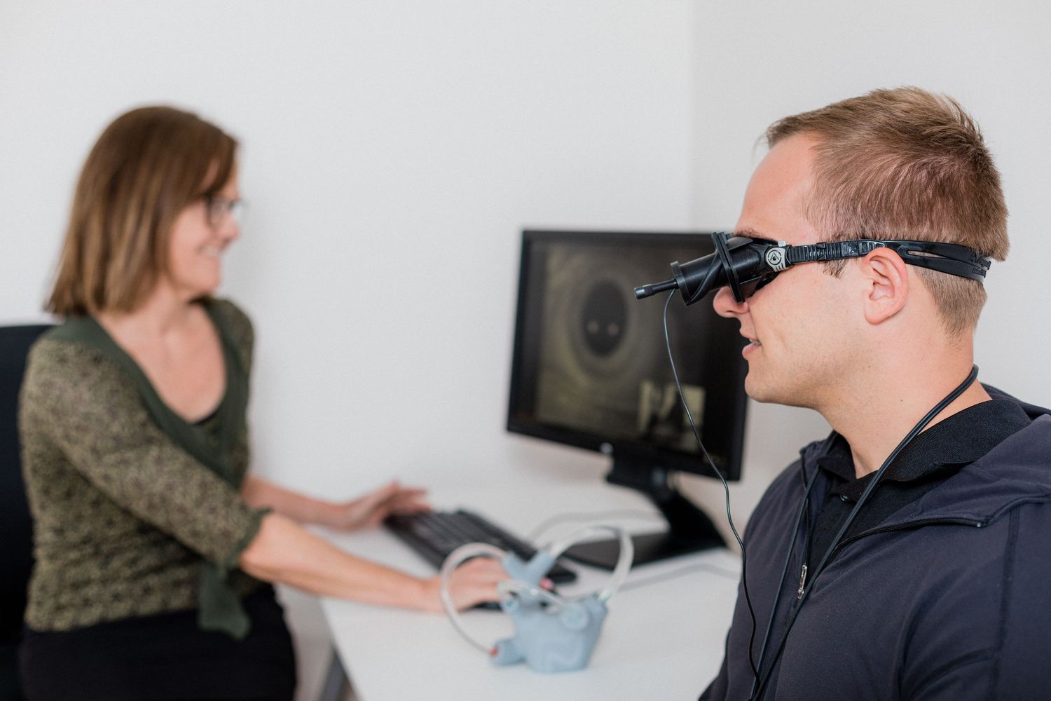 Medical professional performing an eye examination with specialized equipment in a clinical setting.