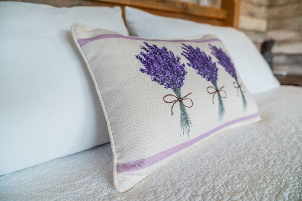 Close-up of a pillow with embroidered lavender bunches, adding a delicate, natural touch to the decor.