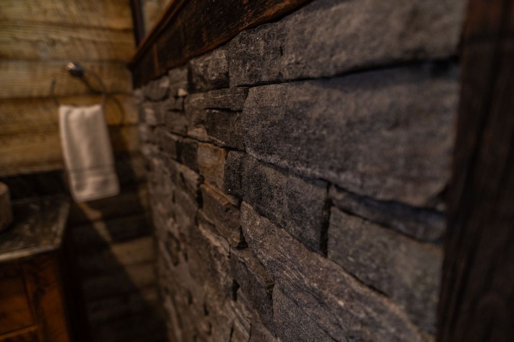 Close-up of a stone half wall in a bathroom, showcasing its textured surface and modern design element.