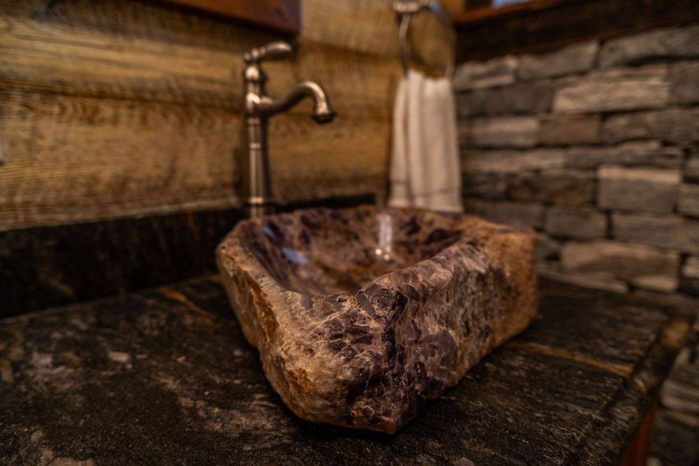 Close-up of a natural amethyst stone sink, showcasing its unique texture and elegant design in a unique bathroom.