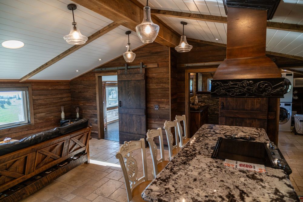 Living room and kitchen in a beautiful wooden house, featuring a cozy couch, stylish counter, and warm rustic design.