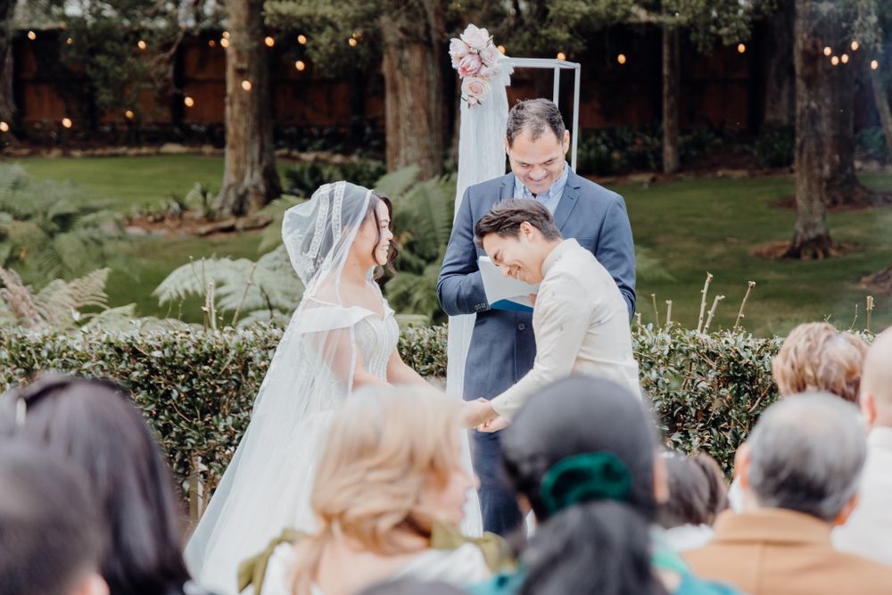 An emotional moment during an outdoor wedding ceremony with guests looking on.