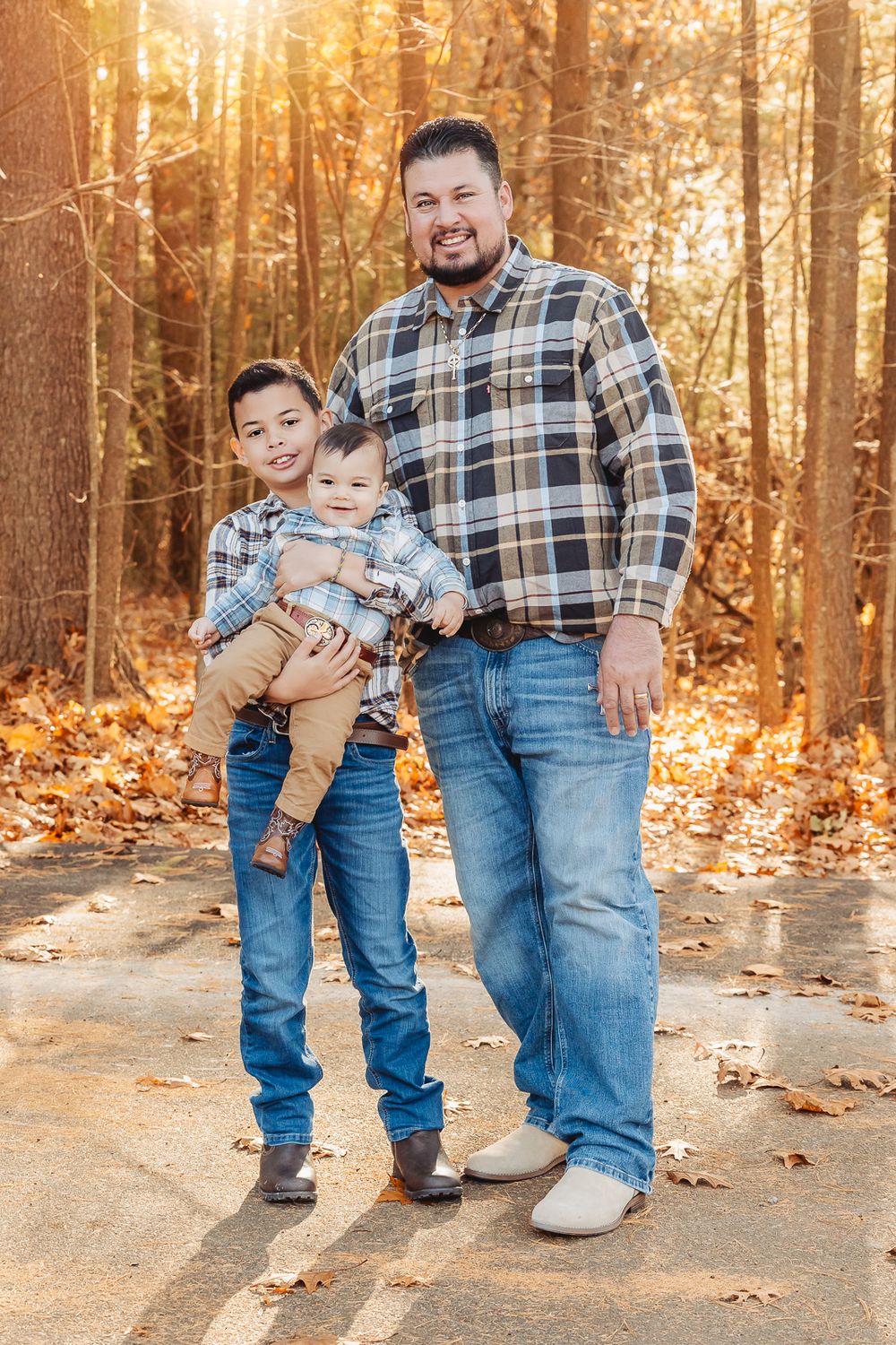 A casual autumn outdoor portrait in a forest with fallen leaves.