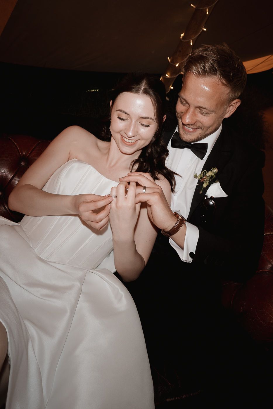 Couple holding sparklers during nighttime wedding celebration in formal attire.