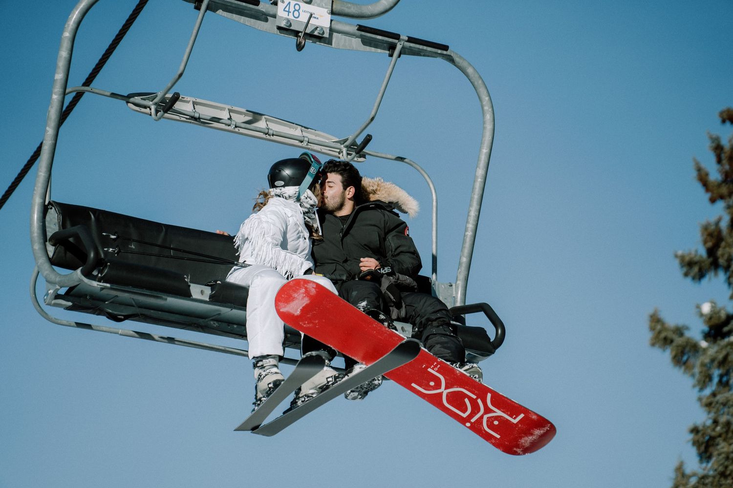 bride and groom kissing on a chairlift