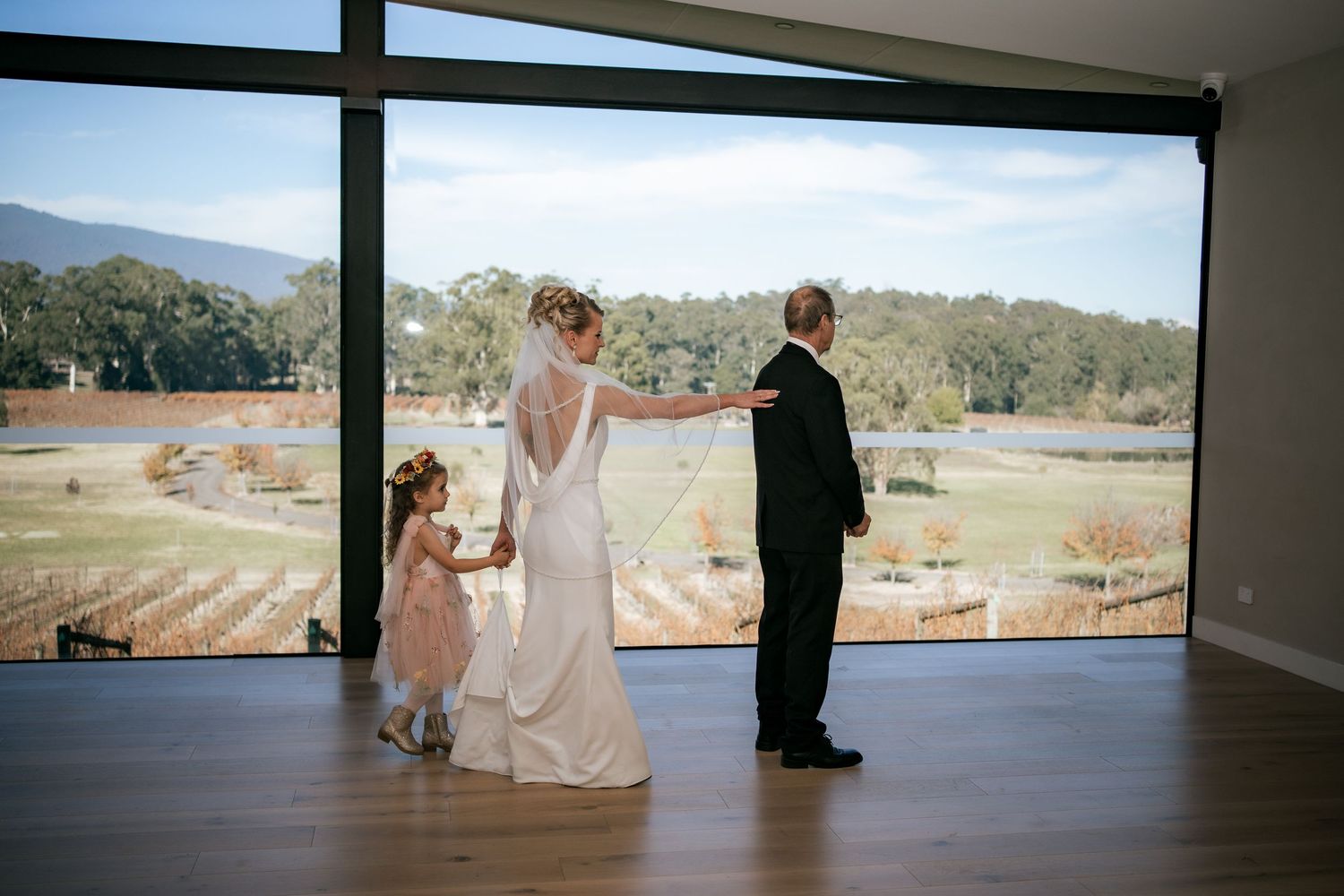 Two people stand together by expansive windows overlooking a scenic mountain landscape in a modern venue.