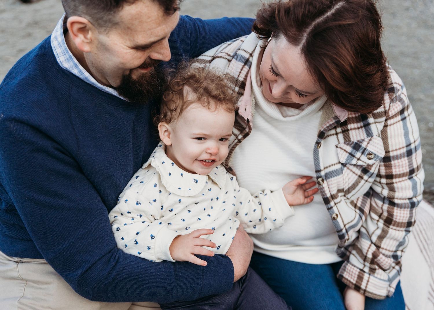 A series of candid family photos showing tender moments between parents and their young child outdoors.