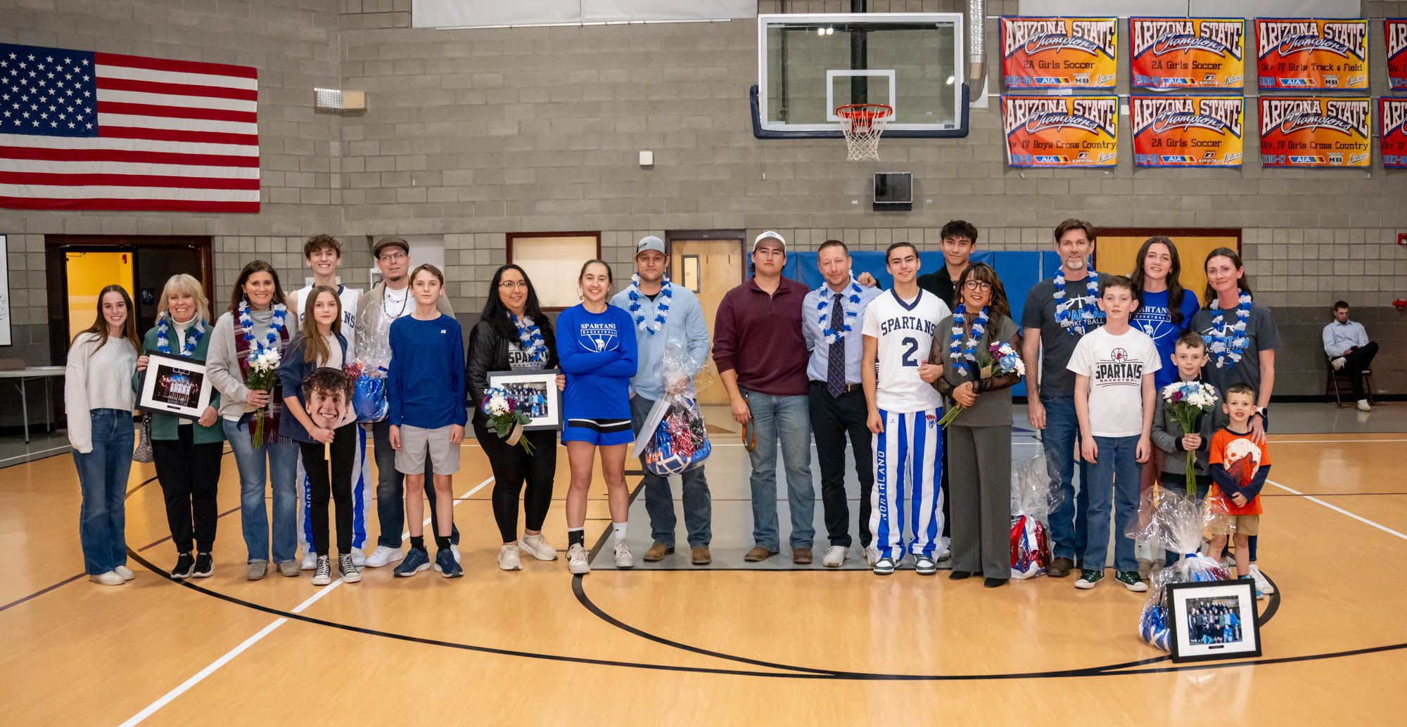 Class of 2025 senior basketball players and their families pose for Flagstaff photographer Sean Openshaw after Senior Night ceremonies.