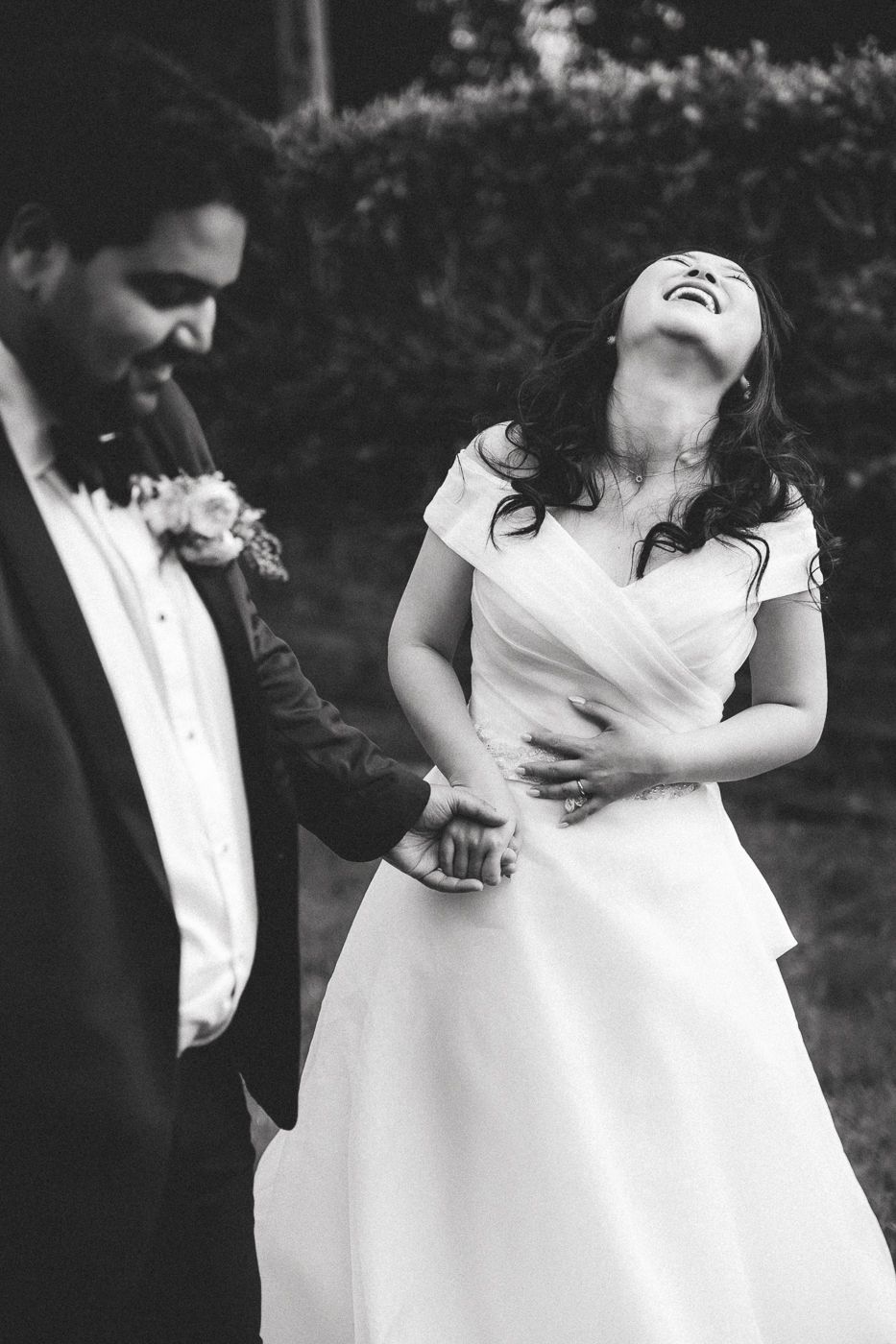 Couple shares their first dance on a black and white checkered floor under dramatic purple-lit Gothic cathedral arches.