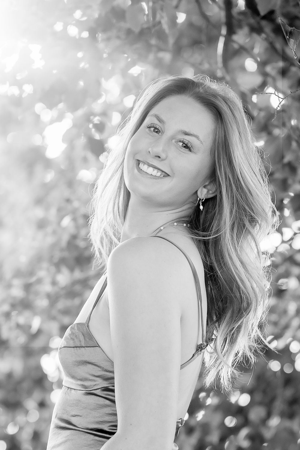 A series of joyful outdoor portraits capturing natural expressions in soft sunlit bokeh.