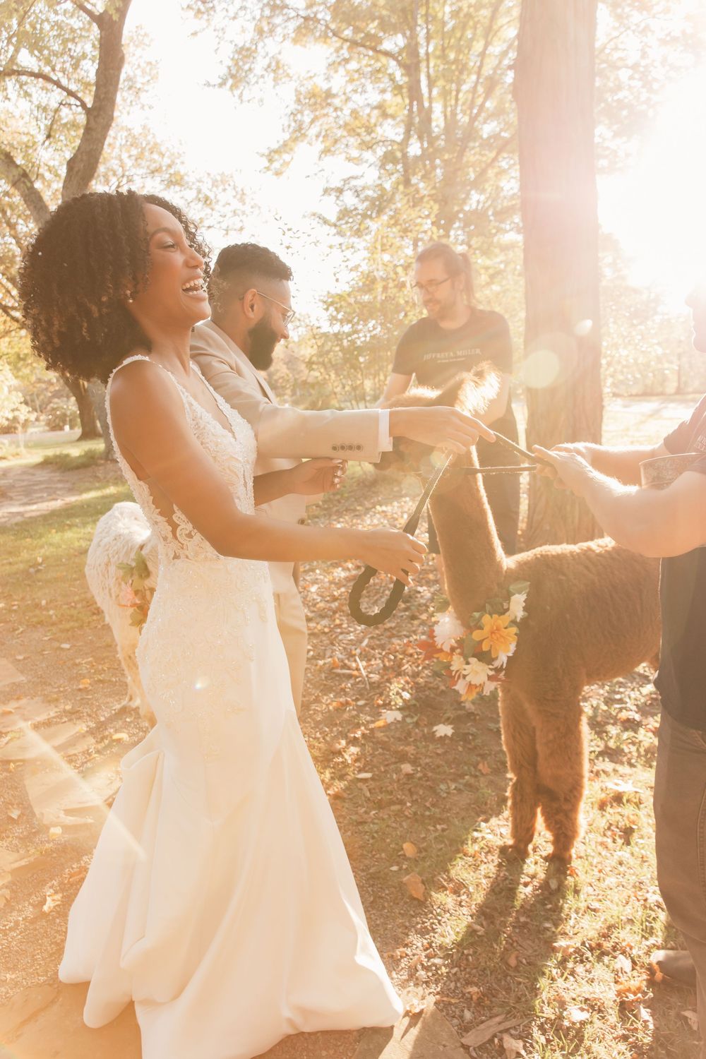A joyful scene of wedding guests sharing drinks outdoors in warm golden sunlight.