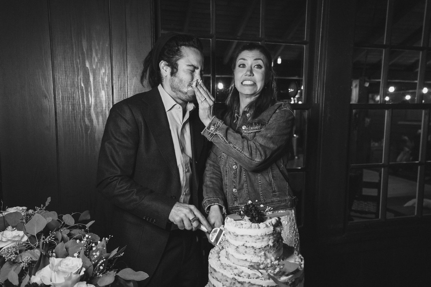 Engaged couple pose for romantic black and white moments during their wedding reception with cake cutting festivities.