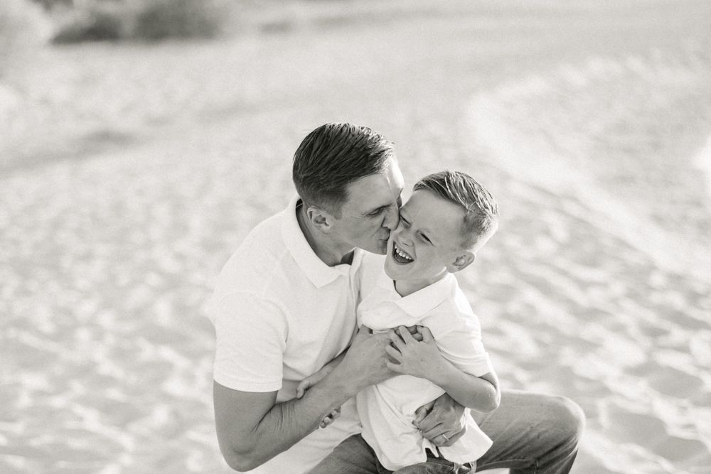 Sweet tender moment shared between parent and child on sandy beach.