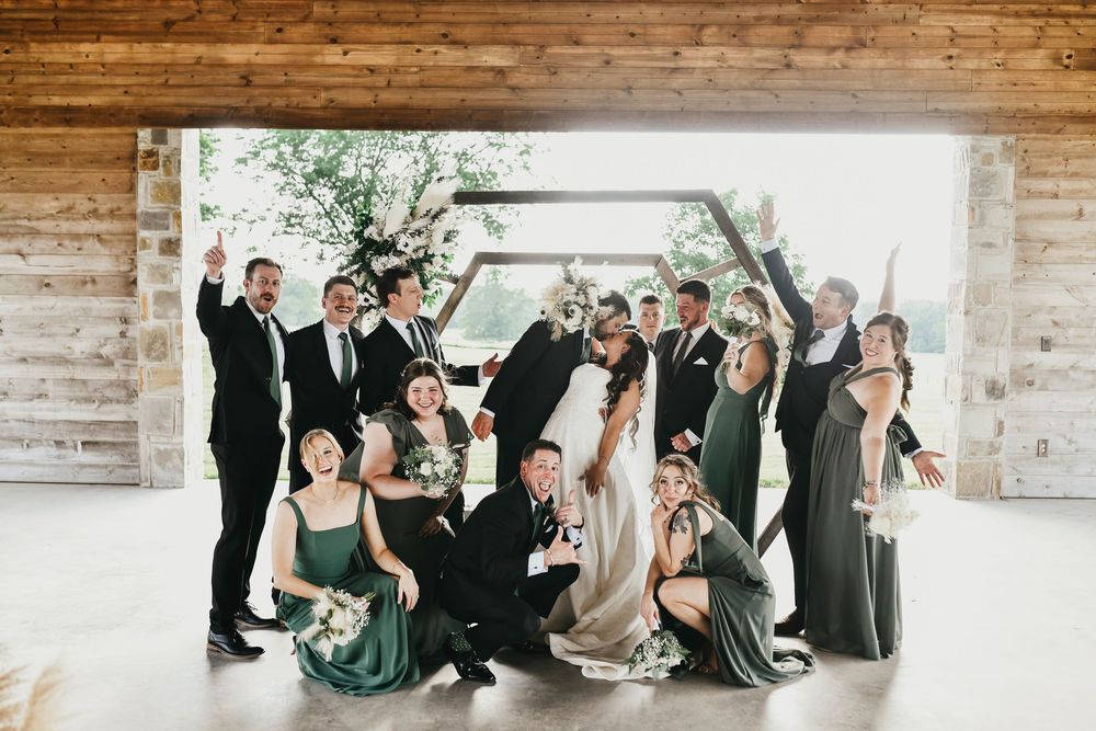 Bride and groom surrounded by laughing friends in matching outfits
