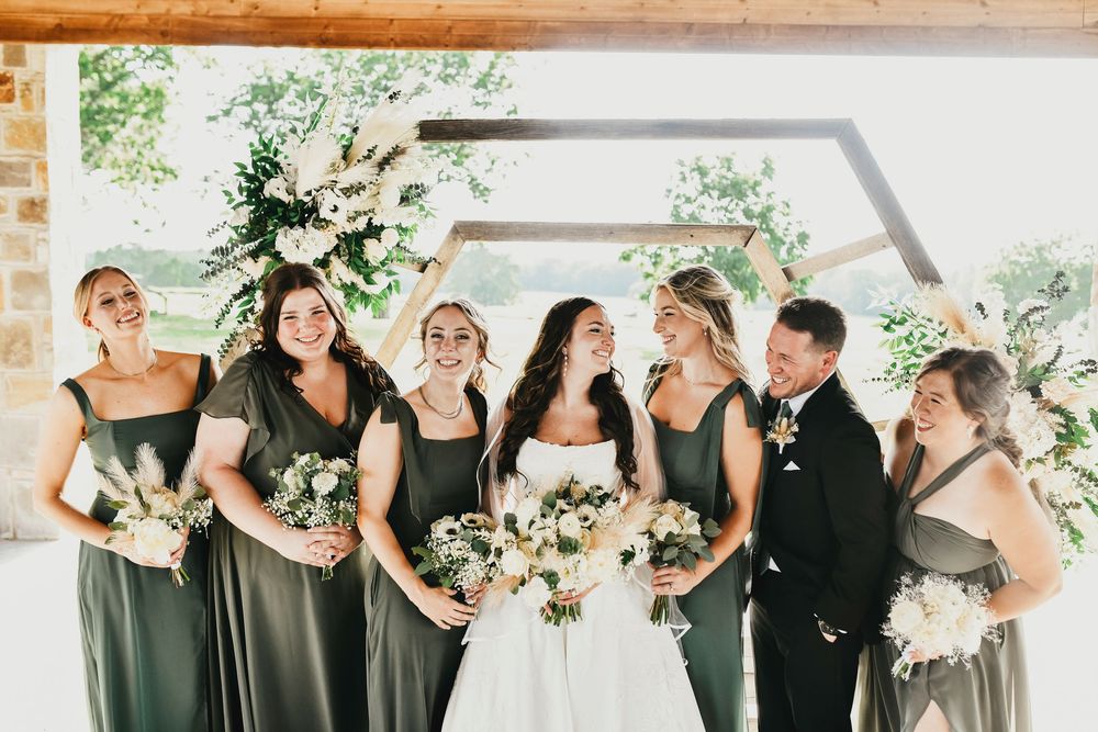 Bride striking a pose with bridesmaids in matching dresses