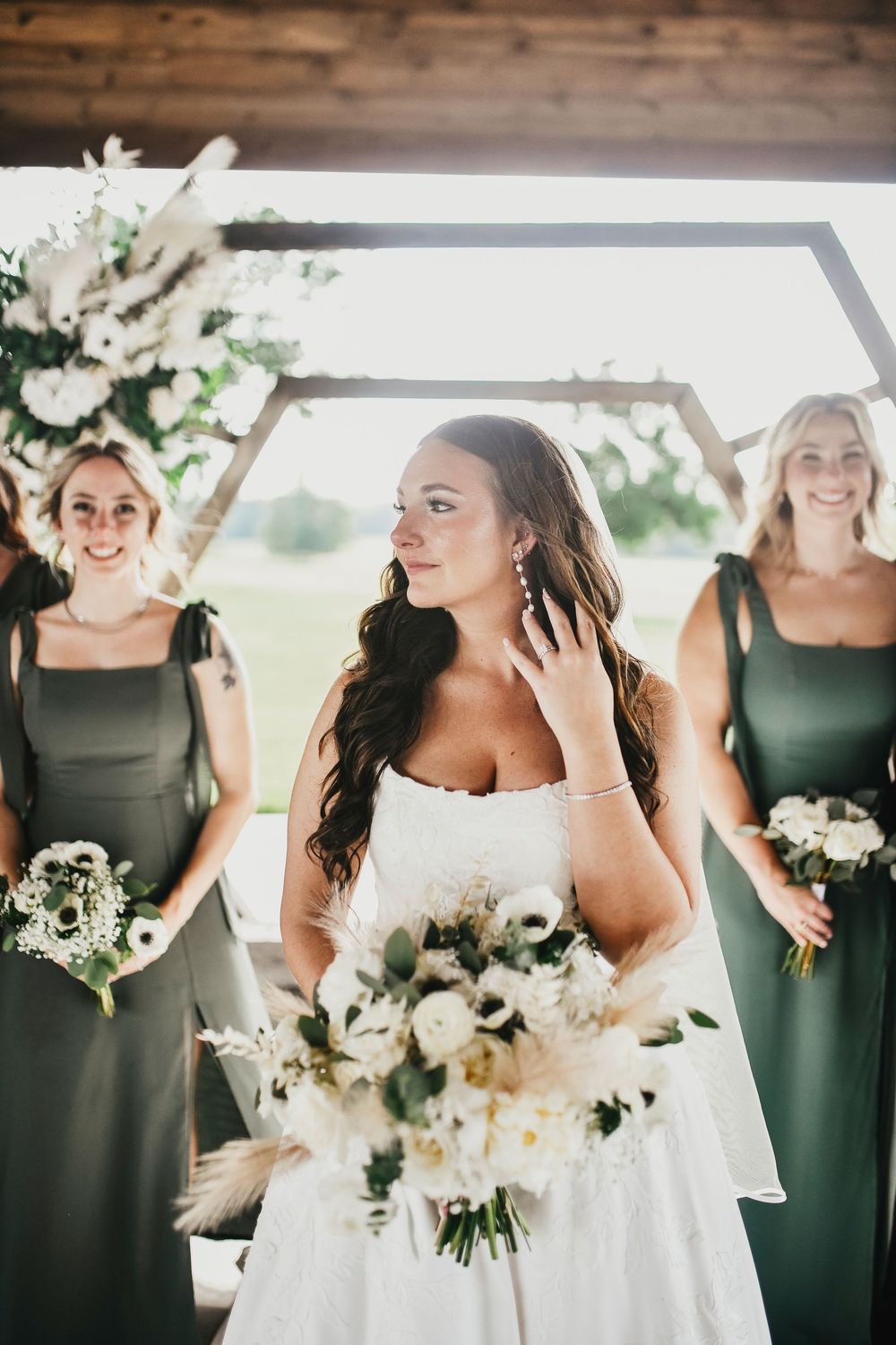 Bridesmaids twirling in satin gowns with bride in the center