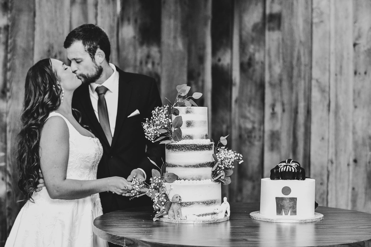 the bride and groom cut their cake and hold a kiss for their wedding photos