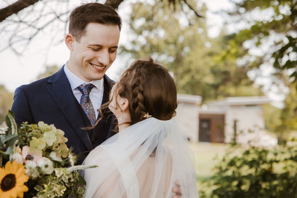 Bride and groom share a quiet first look before their Prairie Village church wedding, captured in golden light with heartfelt reactions..