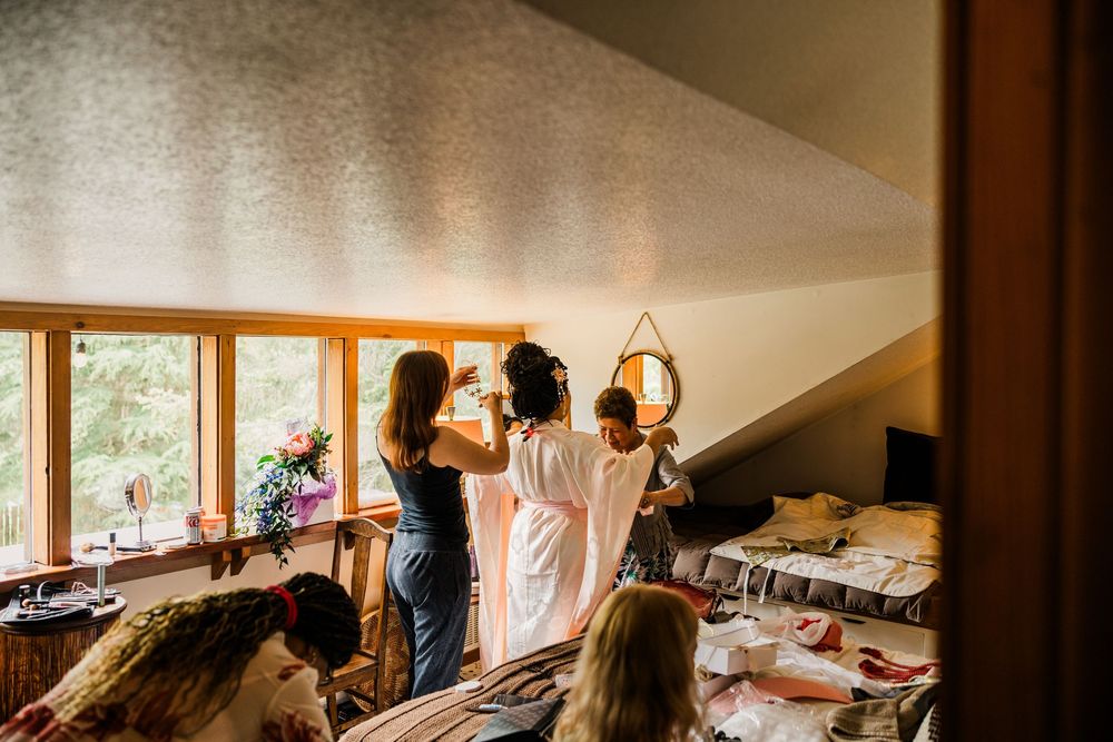 Wedding preparation scene with silhouettes getting ready by sunlit windows.