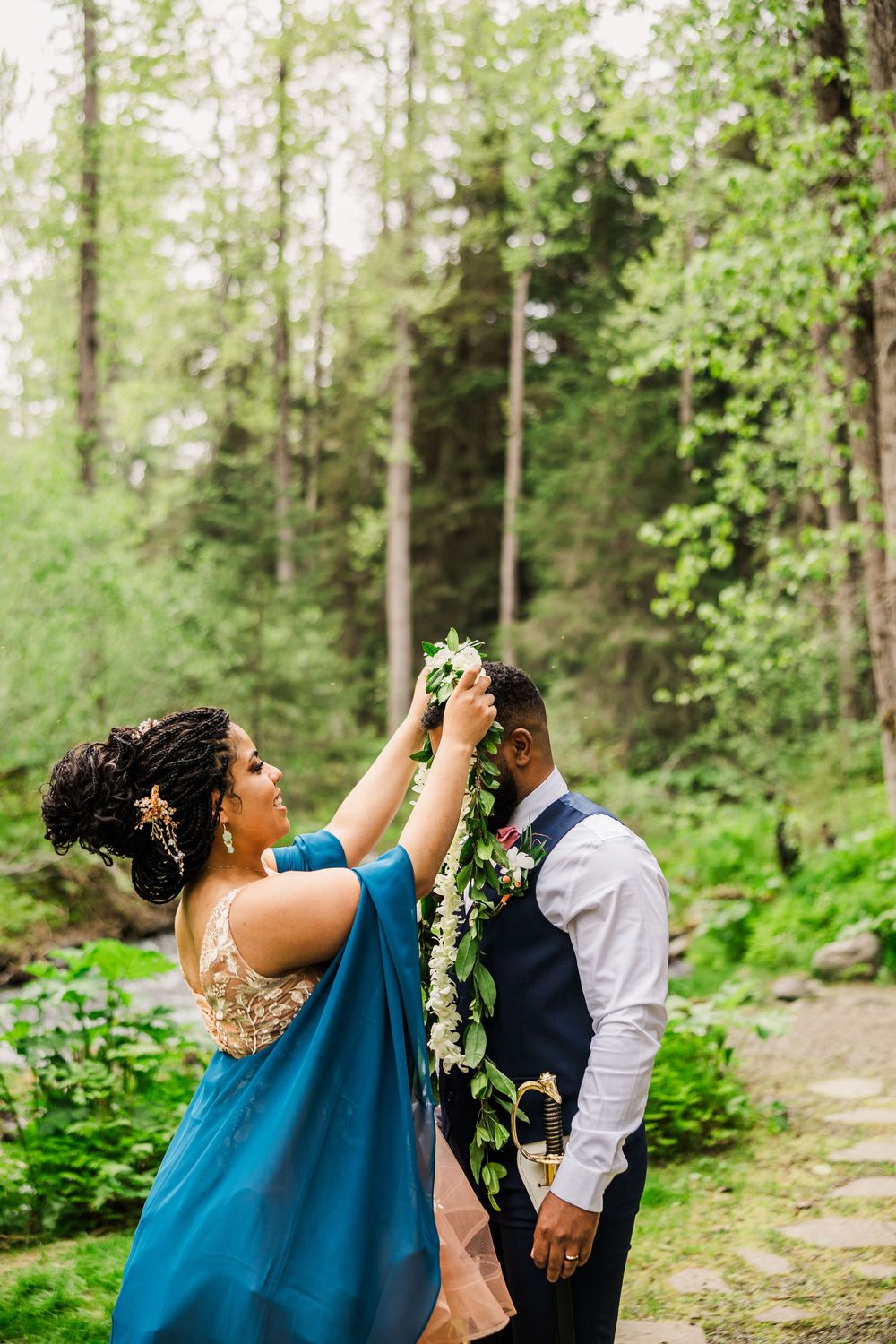 Joyful wedding moment captured on a forest path with natural greenery surrounding.