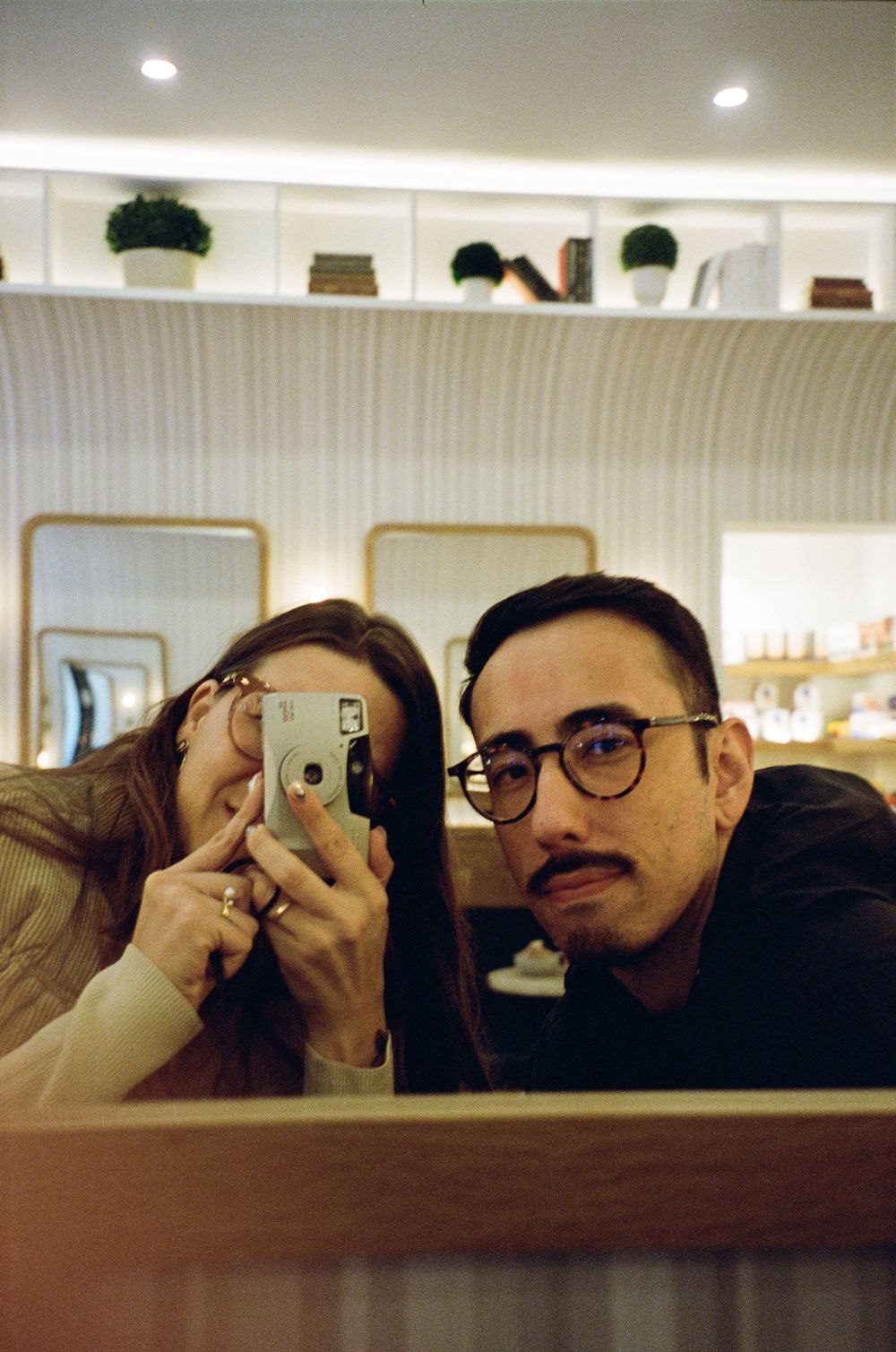 Mirror selfie showing a playful moment in an interior space with modern decor.