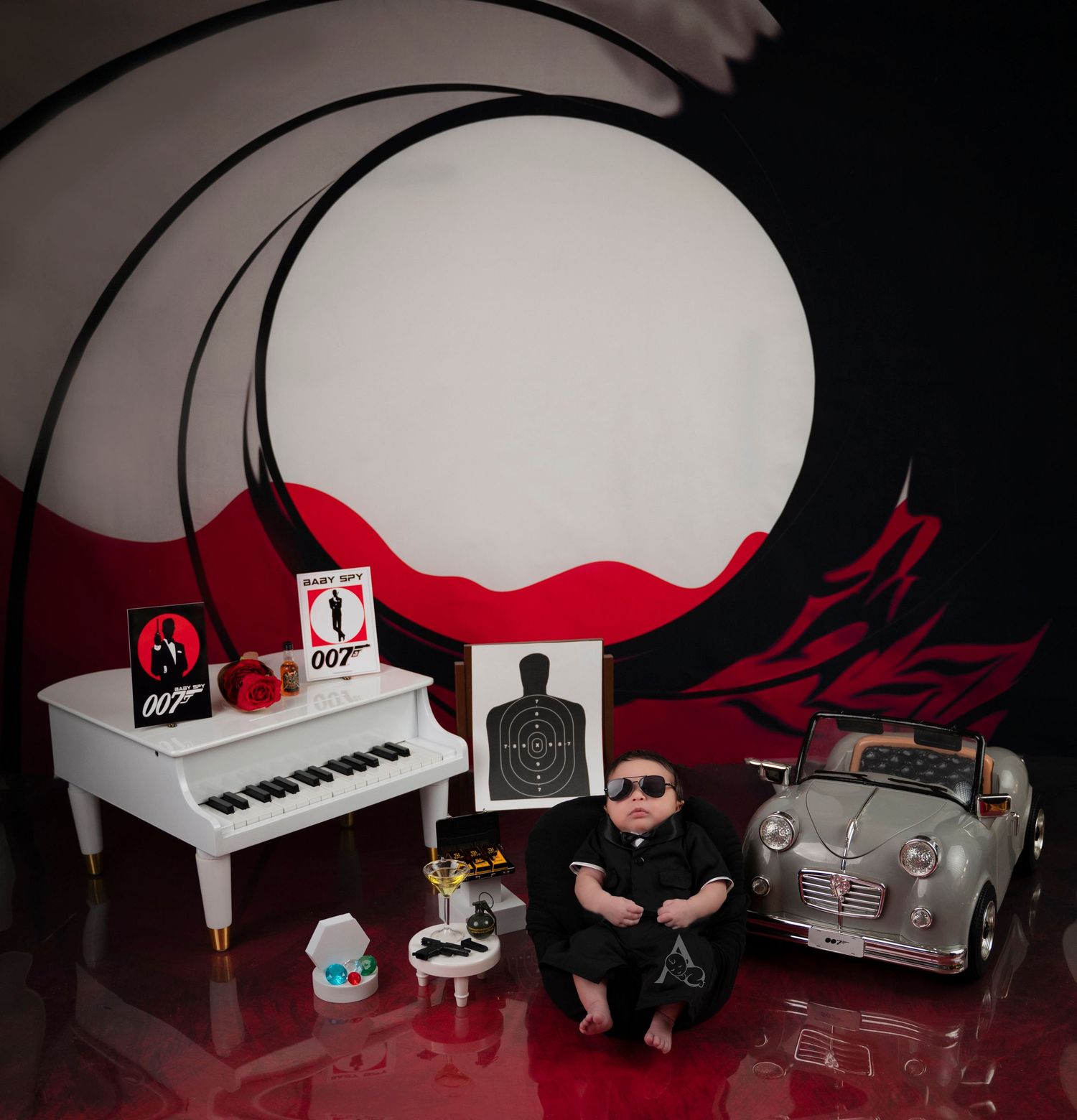 Miniature scene with toy piano, vintage car, and dark dramatic lighting against red and black background.